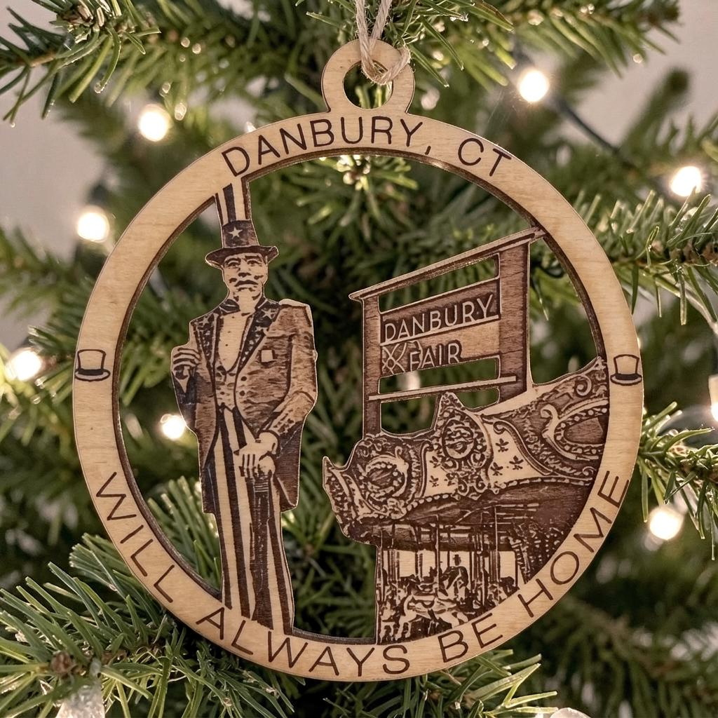 Mellow Monkey 4-inch round wooden ornament featuring Danbury Fair imagery and text hanging on a Christmas tree