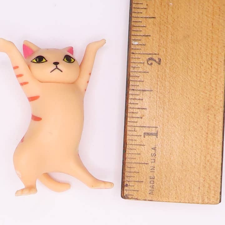 Mellow Monkey 2-inch dancing cat figurine with orange stripes standing next to a wooden ruler for scale