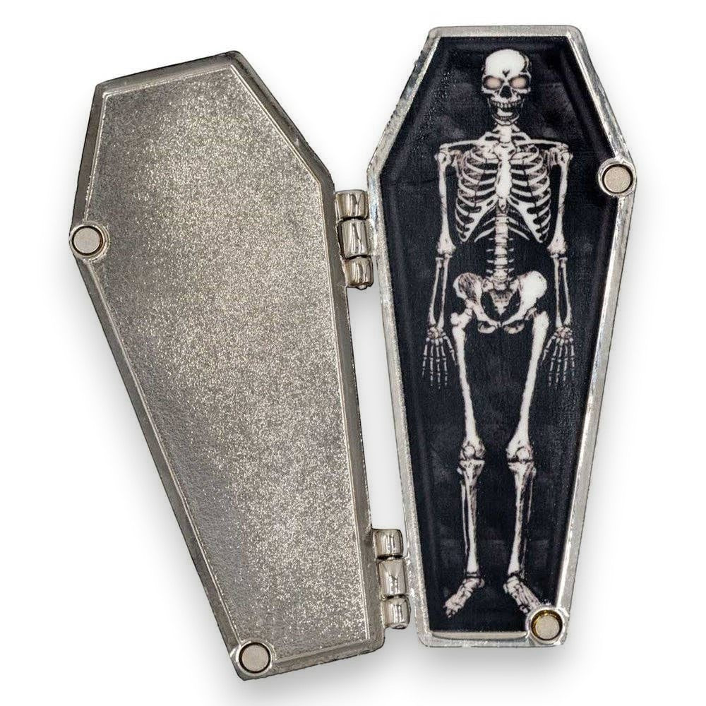 Mellow Monkey Dead Inside open coffin enamel pin with a hinged magnetic door revealing a detailed skeleton inside.