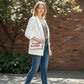 Model wearing a Mellow Monkey Diet Coke can novelty shoulder bag with a white blazer, grey top, and blue jeans.