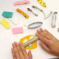 Mellow Monkey DIY hair clip kit with colorful polymer clay, metal clips, clay cutters, and a small wooden roller.