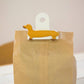 Mellow Monkey yellow dachshund bag clip on a brown paper bag. Made from ABS and spring steel.