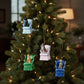 Mellow Monkey resin dog in wingback chair ornaments in blue, pink, and green hanging on a Christmas tree