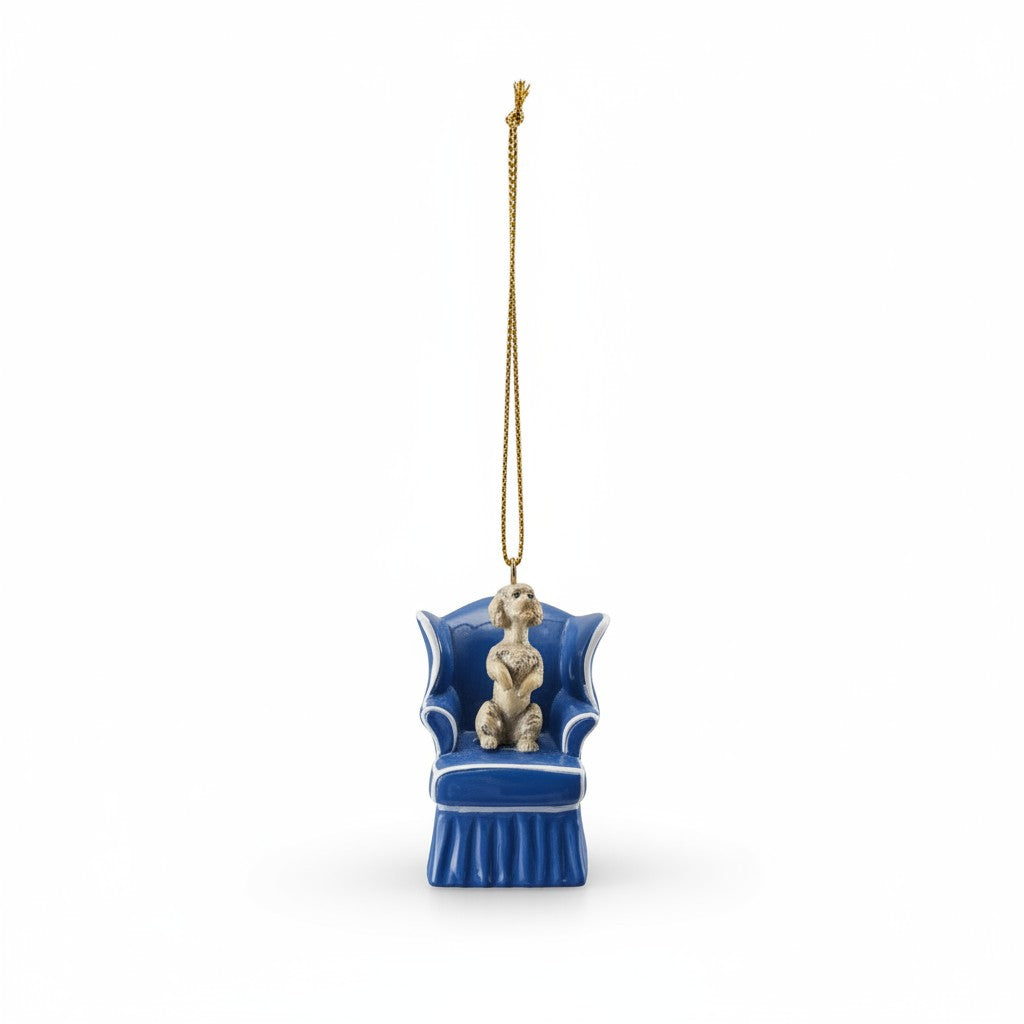 Mellow Monkey resin dog ornament featuring a sculpted pup sitting in a blue wingback chair with a gold hanging cord.