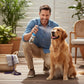 Mellow Monkey Really Good Doggie Deodorizer spray being applied to a golden retriever by a smiling man outdoors