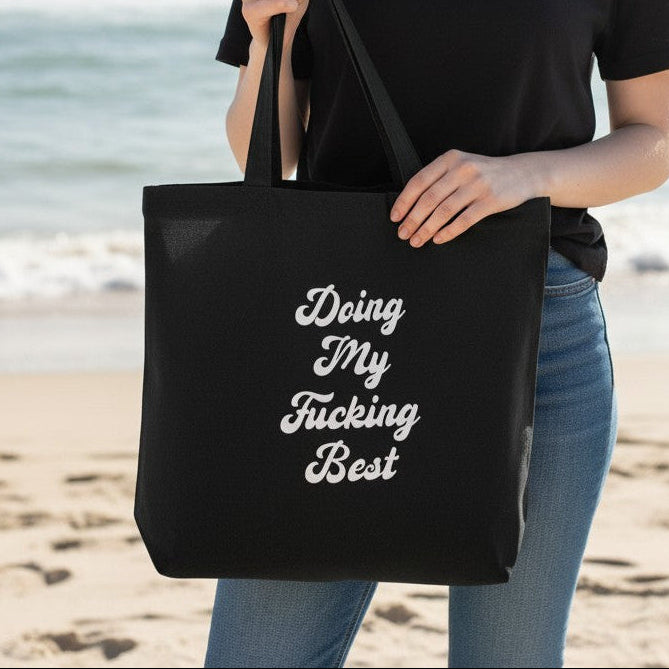 Mellow Monkey black 100% cotton tote bag with white "Doing My Fucking Best" text. Spacious and durable for everyday use.