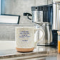 Mellow Monkey XO Dolly ceramic mug with speckled finish and inspirational Dolly Parton quote on a kitchen counter