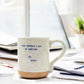 Mellow Monkey XO Dolly ceramic mug with speckled finish and Pour Yourself A Cup Of Ambition quote on a desk