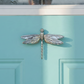Mellow Monkey nickel silver dragonfly door knocker mounted on a light blue front door