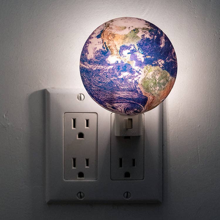 Mellow Monkey Earth night light plugged into a wall outlet, featuring a detailed globe design with soft illumination.