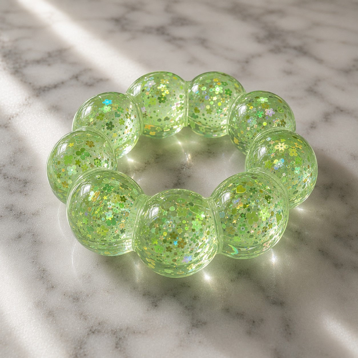 Mellow Monkey Ecto Cooler Feelzies Original sensory bracelet in translucent lime green with glitter and flower shapes.