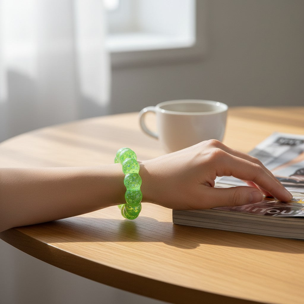 Mellow Monkey Ecto Cooler Feelzies Original Squishy sensory bracelet in bright green worn on a wrist at a desk.
