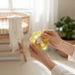 Mellow Monkey Electric Lemon Feelzies sensory bracelet being squeezed by hands in a bright, airy room.