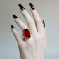 Mellow Monkey Elvira gothic coffin ring with a red acrylic skull jewel on an adjustable gold alloy band.