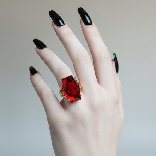 Mellow Monkey Elvira gothic coffin ring with a red acrylic skull jewel on an adjustable gold alloy band.