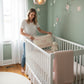 Mellow Monkey embroidered Thank Heaven For Little Girls pillow held by a woman in a sage green nursery
