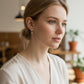 Mellow Monkey handmade espresso martini stud earrings worn by a woman in a bright, casual setting.
