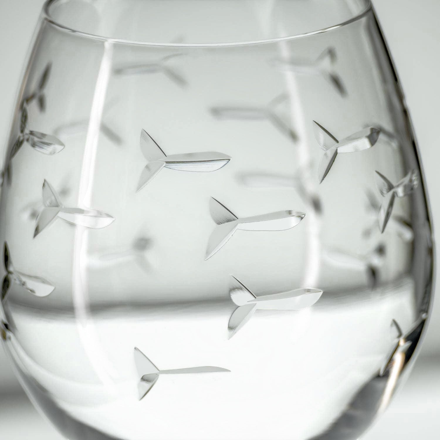 Mellow Monkey 18-oz balloon red wine glass featuring an etched and polished school of fish design on clear glass.