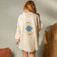 Mellow Monkey cream 4-layer muslin kimono robe with hand-painted blue and gold evil eye design on back. One size.