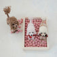 Mellow Monkey fabric poodle ornaments with curly textured fur and festive bows in a wooden tray with pink pom-poms