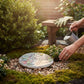 Mellow Monkey round garden stepping stone with floral hummingbird design and inspirational faith quote in a garden