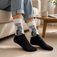 Mellow Monkey bamboo knit socks featuring a grumpy grey tabby cat and the text Feed Me & Leave on a black and white base