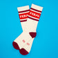Mellow Monkey Feral gym crew socks in cream with maroon stripes and text on a bright blue background.