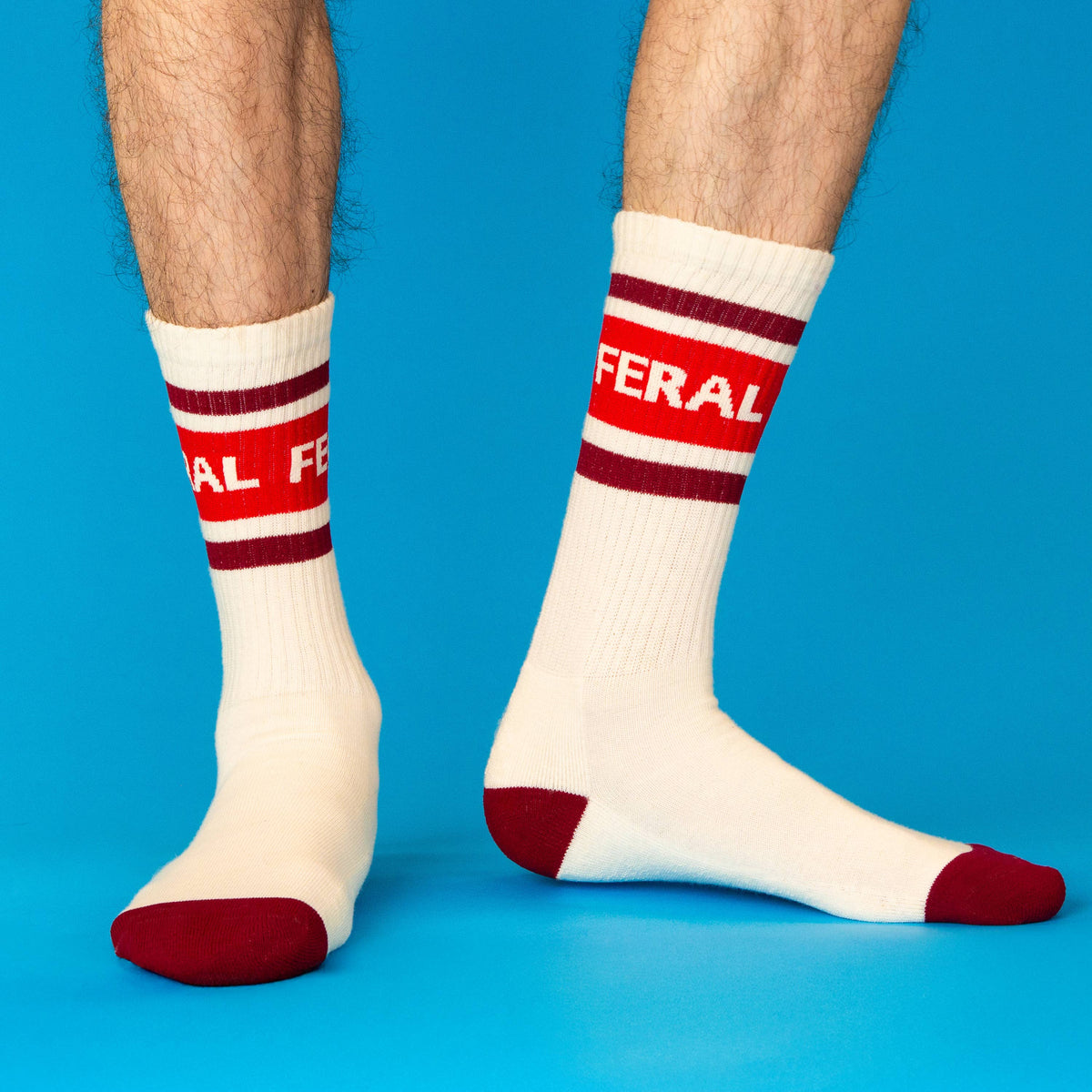 Mellow Monkey cream gym crew socks with red stripes and the word FERAL printed on the mid-calf cuff