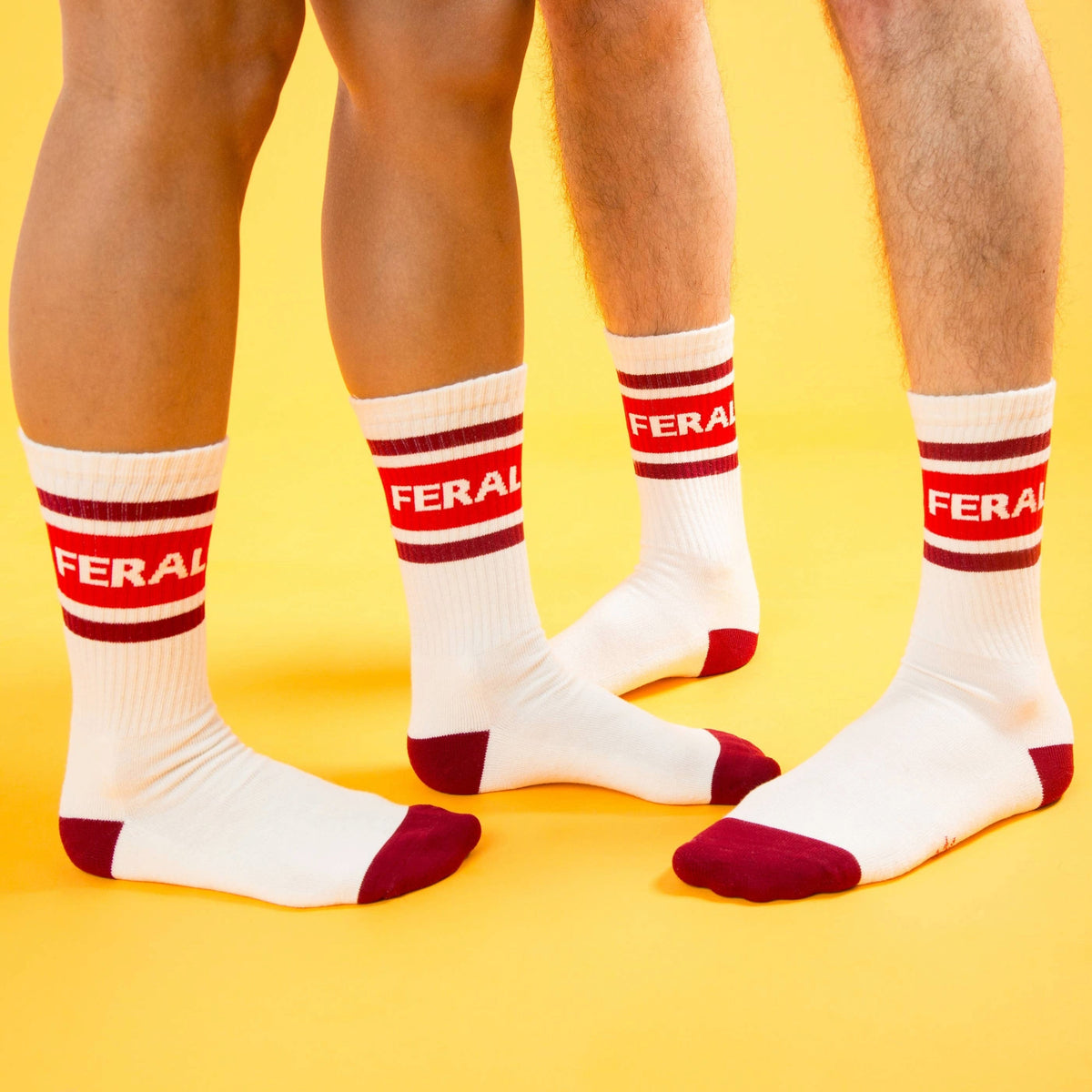 Mellow Monkey Feral gym crew socks in white with red stripes and FERAL text on a yellow background