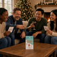 Mellow Monkey festive trivia game box on a wooden table with a group of friends playing in a cozy living room.