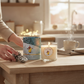 Mellow Monkey First Snowfall soy candle with Richard Scarry artwork, featuring a lit wick and decorative gift box.