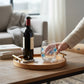 Mellow Monkey stemless wine glass with blue fish bubble design on a wooden tray with a wine bottle and corkscrew