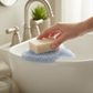 Mellow Monkey fish-shaped crystal blue bioplastic soap lift holding a bar of soap over a bathroom sink