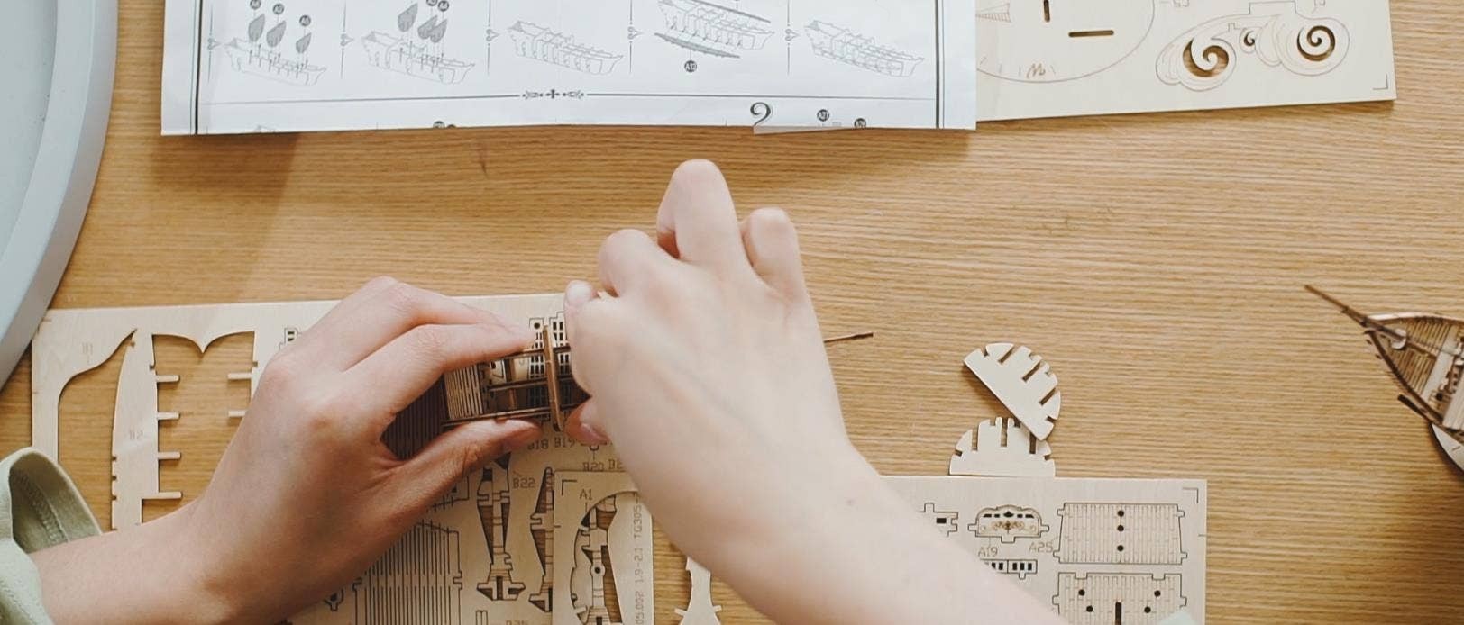 Mellow Monkey 3D laser cut wooden fishing ship puzzle being assembled. Natural wood pieces.