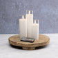 Mellow Monkey set of three white flameless LED pillar candles in glass sleeves with a remote control on a wood tray.