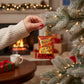 Mellow Monkey Flamin' Hot Cheetos blown glass holiday ornament, shaped like a snack bag, with glittery red and orange finish.