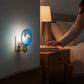Mellow Monkey stained glass flamingo nightlight with blue background and copper finish plugged into a bedroom wall