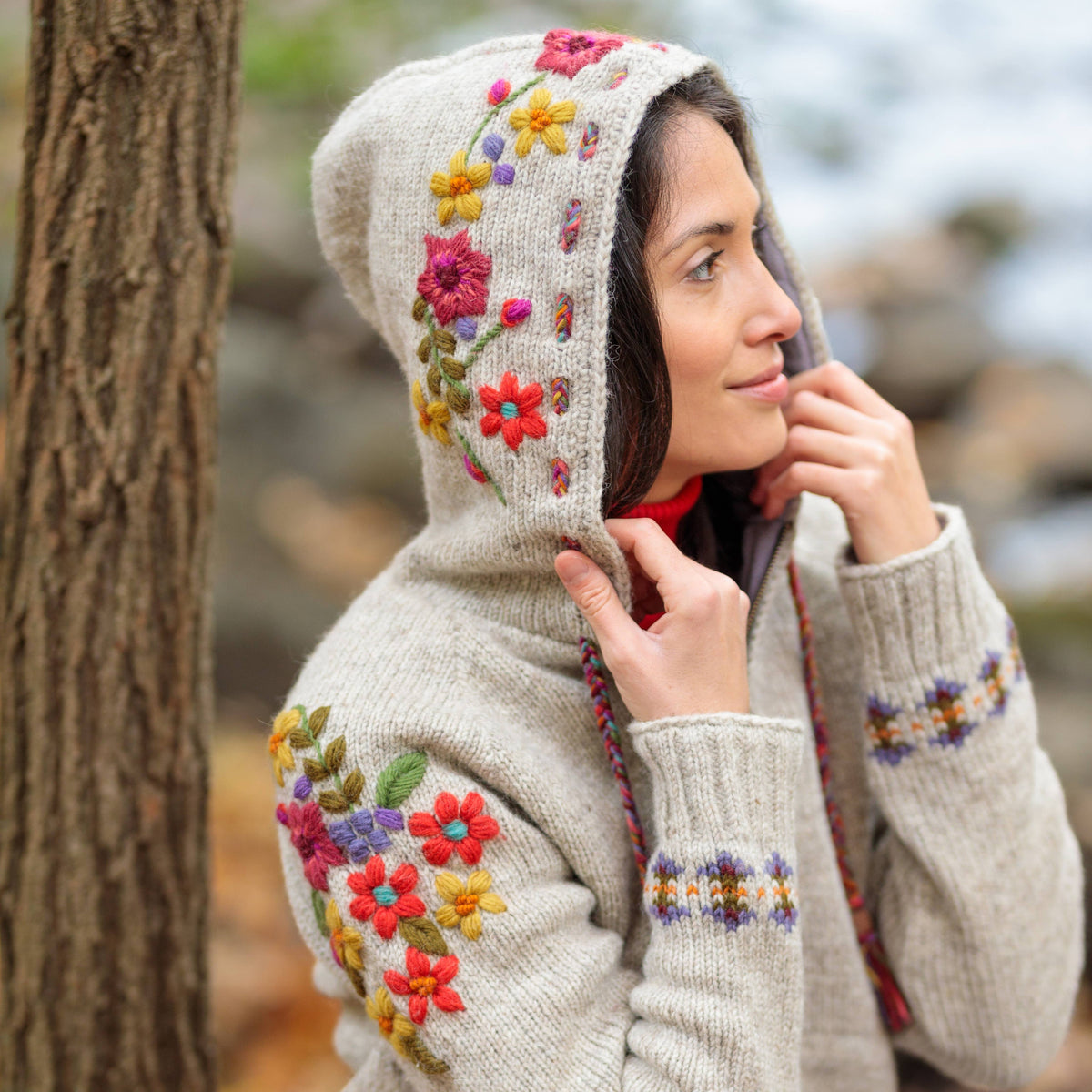 Mellow Monkey light natural wool zip hoodie featuring vibrant floral embroidery on the hood and sleeves with braided drawstrings.