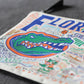 Mellow Monkey University of Florida zip pouch featuring a woven Gator mascot design on durable polyester fabric.