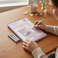 Mellow Monkey Fragrant Blooms FlowArt color-to-reveal set with markers on a wooden desk with a woman coloring.