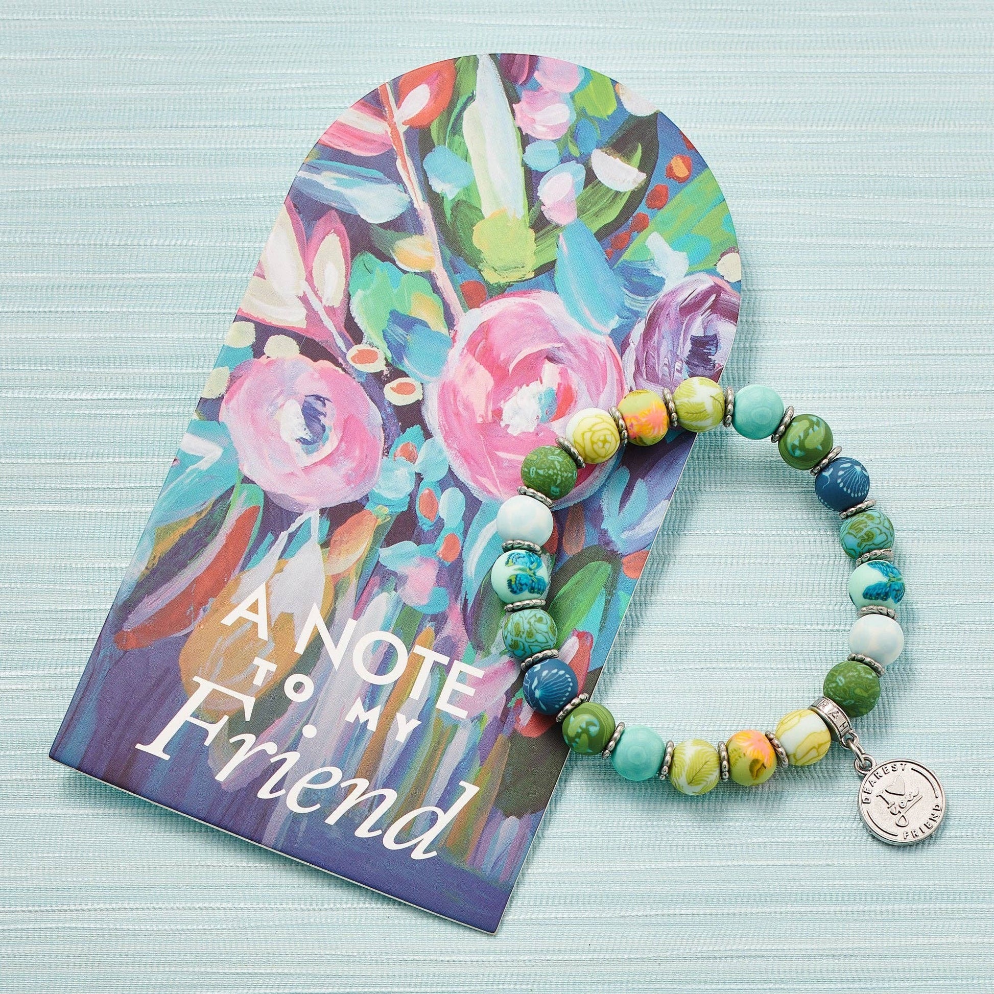 Mellow Monkey Friend bracelet with colorful polymer clay beads, silver spacers, and a prayer box charm on a display card
