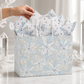 Mellow Monkey large frosted poinsettia gift bag with gloss print, twisted handles, and included decorative tissue.