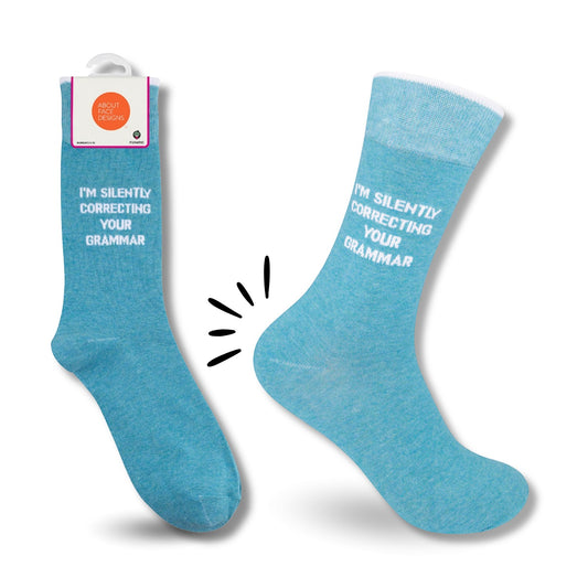 Mellow Monkey light blue novelty socks with white text reading I'm Silently Correcting Your Grammar