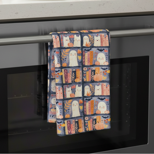 Mellow Monkey waffle dish towel with cute ghost and bookshelf print hanging on a modern kitchen oven handle
