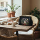 Mellow Monkey black linen blend kisslock bag with embroidered ghost and strawberry field design on a cafe table.