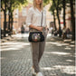 Mellow Monkey linen blend kisslock bag with ghost and strawberry embroidery, worn as a crossbody by a blonde model.