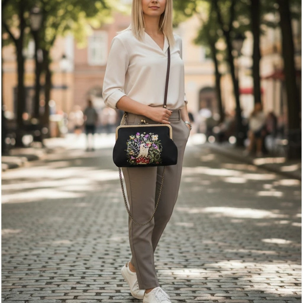Mellow Monkey linen blend kisslock bag with ghost and strawberry embroidery, worn as a crossbody by a blonde model.
