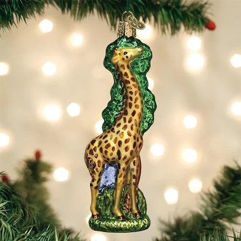 Mellow Monkey Old World Christmas blown glass giraffe ornament with green tree detail. 5.5-inch.