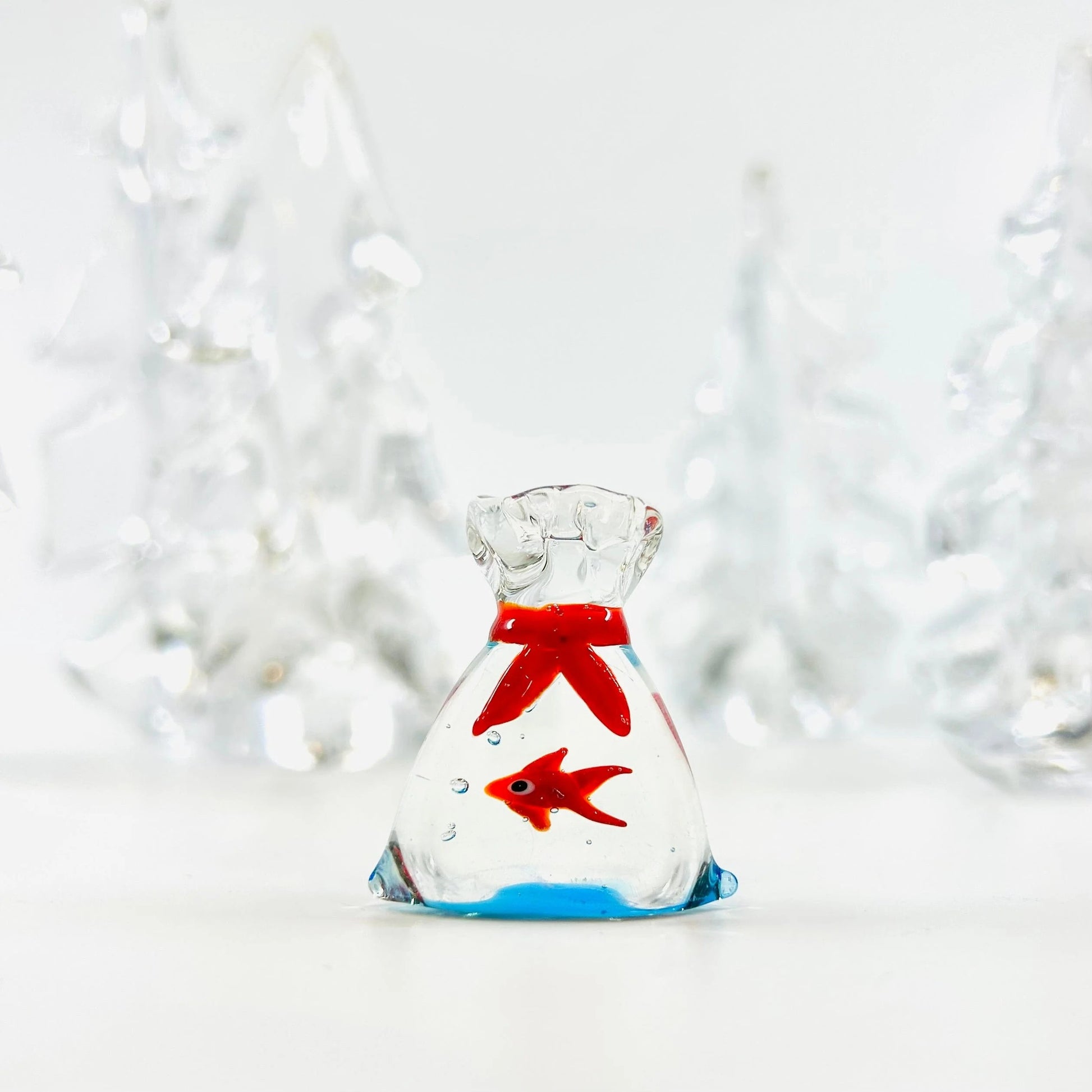 Mellow Monkey 1-inch miniature glass bag containing a tiny red glass fish with a red ribbon detail