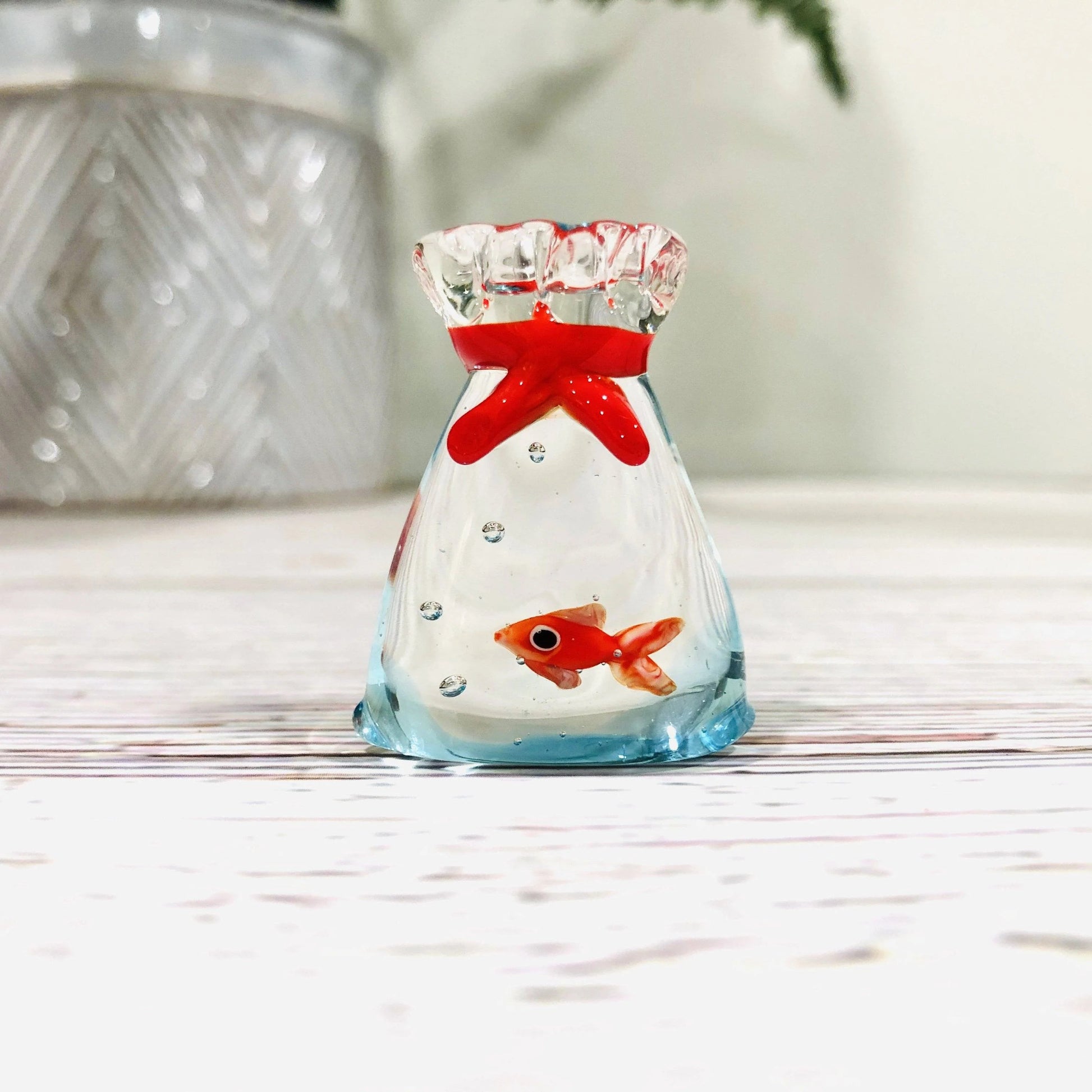 Mellow Monkey 1-inch miniature glass goldfish figurine inside a clear glass bag with a red tie detail